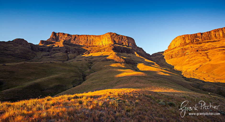 Looking up Giants Pass as the first rays of sunlight illuminate the high peaks of Giants Castle. Notice our tent in the bottom right of the scene!